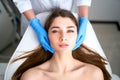 Beautician hands in gloves touching face of attractive woman. Facial Beauty. Beautiful young female with soft smooth