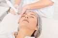 Beautician makes aqua exfoliation for rejuvenation woman face skincare, procedure in beauty salon