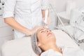 Beautician makes aqua exfoliation for rejuvenation woman face skincare, procedure in beauty salon