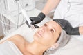 Beautician makes aqua exfoliation for rejuvenation woman face skincare, procedure in beauty salon