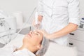 Beautician makes aqua exfoliation for rejuvenation woman face skincare, procedure in beauty salon