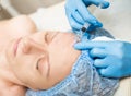 Beautician makes biorevitalization to young woman. The cosmetic procedures for the face. Beauty treatments in the spa