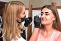 Beautician makes eyebrow coloring with henna to a young woman in a beauty salon Royalty Free Stock Photo