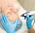 Beautician makes fractional mesotherapy to young woman. The cosmetic procedures for the face. Beauty treatments in the