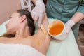 A beautician makes a sugar paste depilation under the armpits in a beauty salon Royalty Free Stock Photo