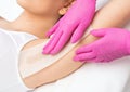 A beautician makes a sugar paste depilation under the armpits in a beauty salon. Female aesthetic cosmetology