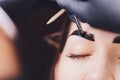 Beautician- makeup artist applies paint henna on previously plucked, design, trimmed eyebrows in a beauty salon in the Royalty Free Stock Photo