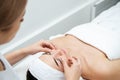 Beautician massaging woman`s face. Attractive girl having facial treatment and massage. The young woman is lying and relaxingin