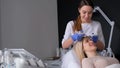 The beautician performs the iontophoresis procedure. Facial skin rejuvenation for women