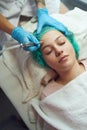 Diamond microdermabrasion. The beautician performs the treatment on a woman& x27;s face.