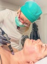 Beautician performs a needle mesotherapy treatment on a woman fa Royalty Free Stock Photo
