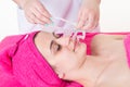 Beautician removes the facial cleansing mask from her client face Royalty Free Stock Photo