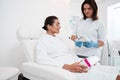 Beautician showing syringe to her patient