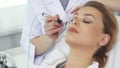 Beautician uses iontophoresis roller for client`s face