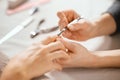Beautician using cuticle pusher on woman hand Royalty Free Stock Photo