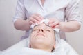 Beautician washes woman`s face using cotton pads. Preparing for a cleaning face