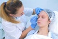 Beautician is wiping eyebrows using cotton pads making eyebrows microblading.