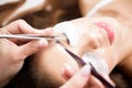 Beautician working on upgrading silk eyelashes in a beauty studio.