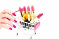 Beautidul hand handle colorful pink Lipstick in a pink shopping cart isolated onwhite background,beauty and shopping concept,sele Royalty Free Stock Photo