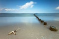 Beautifil beach with breakwaters with a cloudy blue sky in the backgroud, perfect for wallpapers