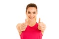 Beautifil young sporty woman shows thumb up as a gesture fo success isolated over white background