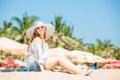 Beautifil young woman sitting on the beach at