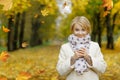 Beautifl blonde girl holding cup of hot tea in beautiful autumn Royalty Free Stock Photo