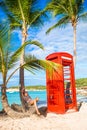 Beautiftul kid near red phone booth in Dickenson`s bay Antigua. Royalty Free Stock Photo