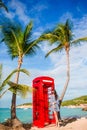 Beautiftul woman near red phone booth in Dickenson`s bay Antigua. Beautiful landscape with a classic phone booth on the Royalty Free Stock Photo