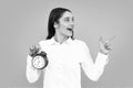 Beautifu women with clock. Portrait of young attractive shocked amazed surprised girl hold clock isolated on gray color Royalty Free Stock Photo