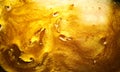 Beautiful abstract golden liquid background, beauty gold backdrop texture. Metallic gold paint. Yellow shimmering surface
