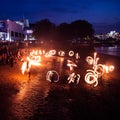 A beautiful, abstract scene of fire spinners in London at the bank of Thames. Nighttime performance.