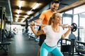 Beautiful active woman doing squats in gym