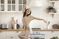 Beautiful active woman enjoy life, dancing alone in cozy kitchen