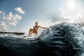 active young woman rides down the wave on a wakeboard Royalty Free Stock Photo