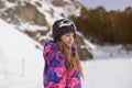 Beautiful adorable active little american girl in ski suit wool hat and goggles on outdoor snow winter mountain resort background