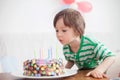 Beautiful adorable four year old boy in green shirt, celebrating