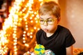 Beautiful adorable seven eight year old boy in grey shirt, celebrating his birthday, blowing candles on homemade baked cake, Royalty Free Stock Photo