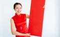 Beautiful adult Asian Chinese woman wearing red traditional dress, posing, holding blank sign to celebrate New Year, standing on