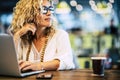 Beautiful adult caucasian people woman work at laptop computer with internet technology - concept of job and modern lady - phone Royalty Free Stock Photo