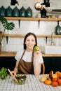 beautiful adult woman with bell peppers looking at camera while making salad at kitche. healthy food concept Royalty Free Stock Photo