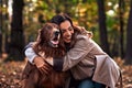 Beautiful adult woman hugging her purebred dog in the autumn park. The concept of beautiful autumn, walking, love, caring for a