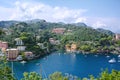 Beautiful aerial daylight view from top to boats on water, colorful houses and villas in Portofino town of Italy.