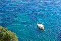 Aerial top view of alone white yacht or boat sailing on azure water, in blue sea, Amalfi coast, Italy