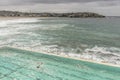 Beautiful aerial view of Bondi Beach on a cloudy day with big waves and a bit of sun filtering through the clouds, Sydney Royalty Free Stock Photo