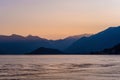 Beautiful aerial view of the famous Como Lake on purple sunset. Clouds reflecting in calm waters of the lake with Alp mountain Royalty Free Stock Photo