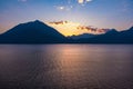 Beautiful aerial view of the famous Como Lake on purple sunset. Clouds reflecting in calm waters of the lake with Alp mountain Royalty Free Stock Photo