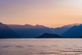 Beautiful aerial view of the famous Como Lake on purple sunset. Clouds reflecting in calm waters of the lake with Alp mountain Royalty Free Stock Photo