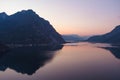 Beautiful aerial view of the famous Como Lake on purple sunset. Mountains reflecting in calm waters of the lake with Alp mountain Royalty Free Stock Photo