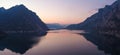 Beautiful aerial view of the famous Como Lake on purple sunset. Mountains reflecting in calm waters of the lake with Alp mountain Royalty Free Stock Photo